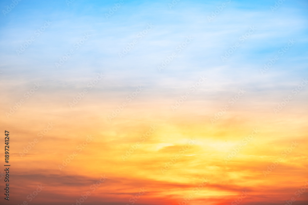 Obraz premium Sunset or sunrise sky with a vibrant gradient of orange, gold, and soft blue. Clear atmosphere with wispy clouds. Peaceful, natural light background. hope, freedom, new day and inspirational Concepts