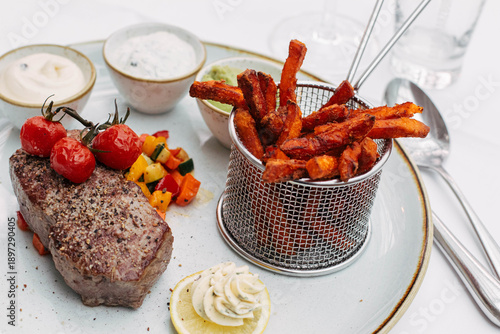 Süßkartoffelpommes mit Steak auf Teller