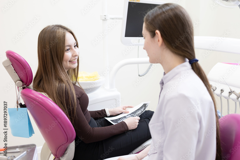 Fototapeta premium A dentist consults a patient with a dental x-ray. A dentist shows a patient an X-ray