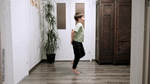 Caucasian boy doing Butt Kicks. Child doing Butt Kick exercise running on the spot at home. Children workout. Strengthening the legs muscles. Strong body. Healthy lifestyle. High quality 4k footage.