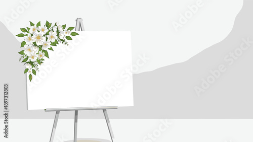 Blank white artist canvas sitting on a grey easel decorated with a cluster of white jasmine flowers and green leaves in a minimalist room.