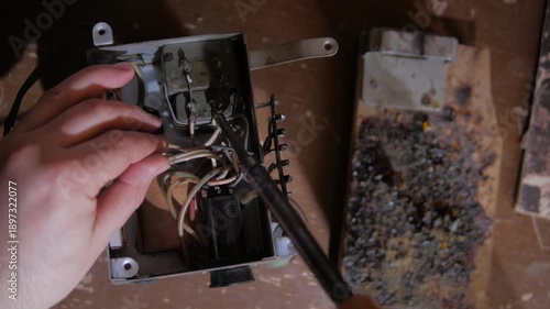 man checks the wire connection on an old radio amplifier