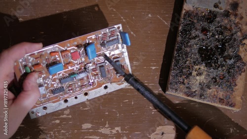 de-soldering the contacts on the radio amplifier using a soldering iron