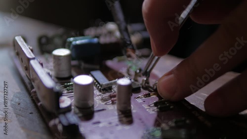soldering a capacitor on a microcircuit radio equipment repair close-up