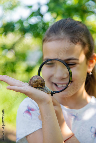 Foto The child examines the snails on the tree. Selective focus.