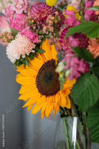 Vibrant sunflower bouquet with colorful assortment of pink and yellow blossoms in vase