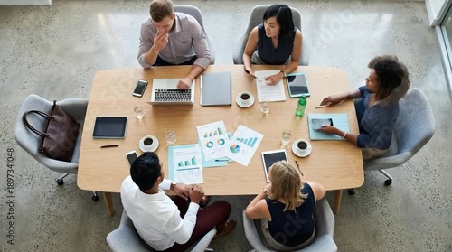 Diverse business team collaborating in a modern office meeting, overhead view