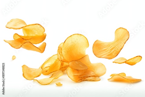 Crispy potato chips scattered and falling against a white background