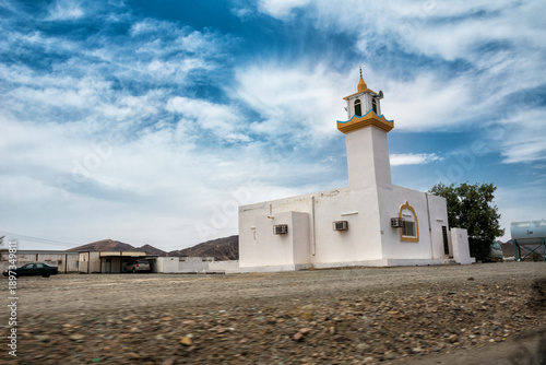 Small mosque in the peaceful countryside of Saudi Arabia surrounded by desert and open landscape under clear sky