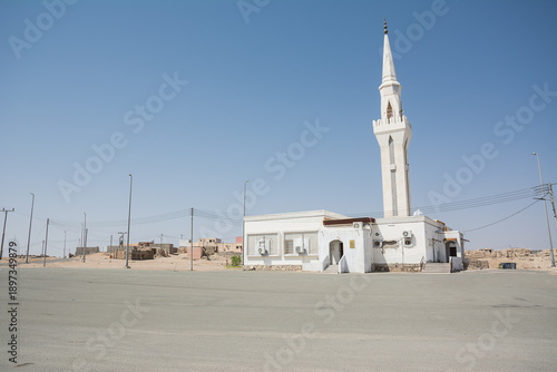 Small mosque in the peaceful countryside of Saudi Arabia surrounded by desert and open landscape under clear sky