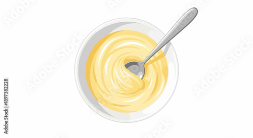 Top-down view of a white bowl filled with creamy yellow sauce, stirred by a silver spoon