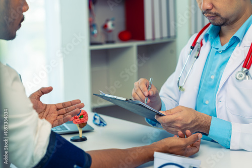 Canvas Print The doctor is showing the patient an anatomical model of the brain