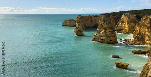 Praia da Marinha, beautiful beach Marinha in Algarve, Portugal. Navy Beach (Praia da Marinha) with flying seagulls over the beach, located on the Atlantic coast in Lagoa Municipality, Algarve.