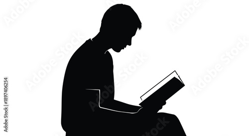 Silhouette of a focused young man deeply engrossed while reading an open book in solitude