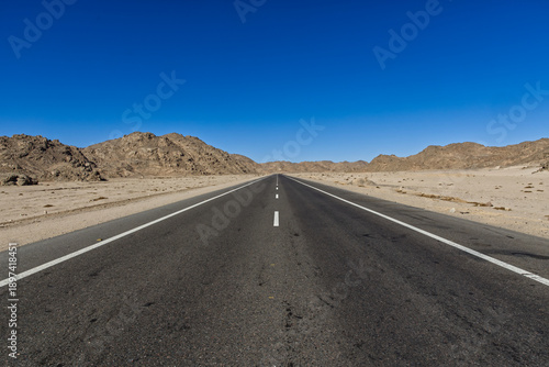 The road - super-quality highway - in the desert with blue cloudy sky in the background, between Dirrot City and Farafra oasis in Egypt