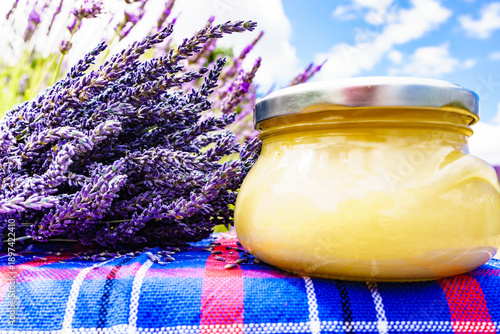 Jar with honey and lavender flowers.