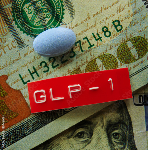 A GLP-1 pill and red label on US hundred dollar bills