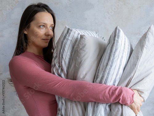 Wallpaper Mural woman holds pile of pillows in her hands. pillows are in different colors, look like stack. female is in a relaxed state. lady makes bed or changes bed linen. linen conditioner, healthy sleep. Torontodigital.ca