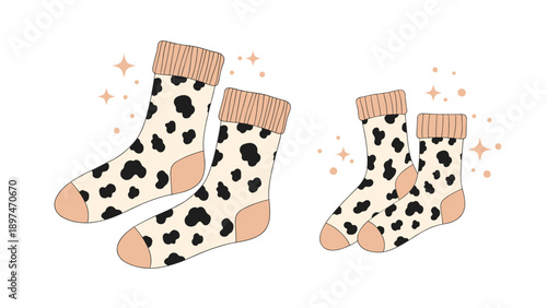 Cute pairs of warm socks featuring stylish black cow print patterns and soft pastel pink accents on a white background.