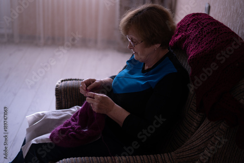Elderly woman knitting in a chair