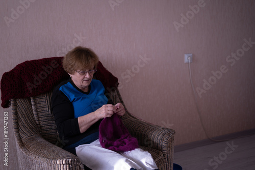 Elderly woman knitting in a chair