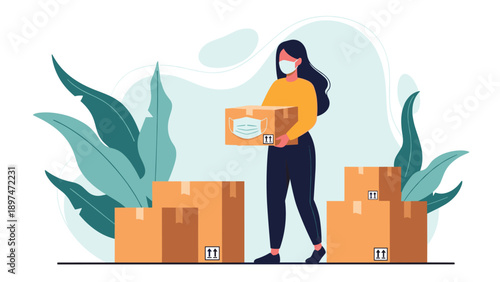 Woman wearing a protective face mask and carrying a box of donations while standing near several other cardboard boxes in a bright room.