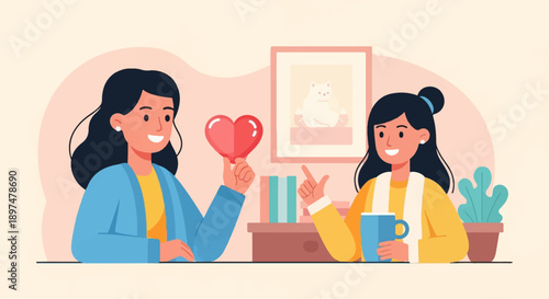 Two smiling women are talking, one holds a heart, a cat picture hangs on wall