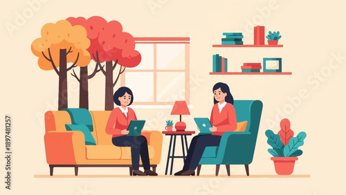 Two women sit in comfortable chairs, working on laptops with autumn trees outside