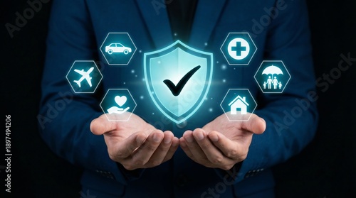 Businessman hands holding digital shield with checkmark featuring icons for life, health, family, home, car, and airplane insurance coverage against dark background.