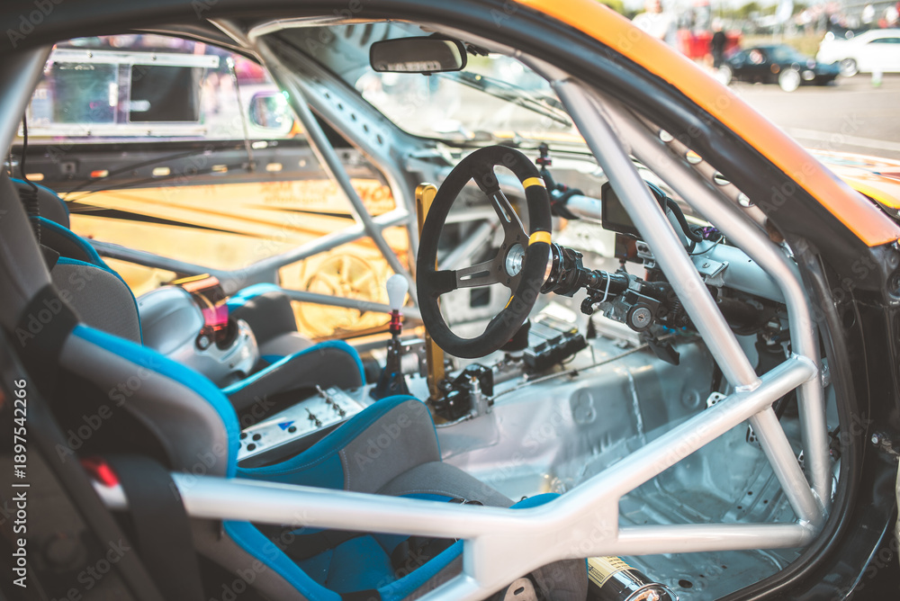 Obraz premium Interior view of a race car with roll cage, steering wheel, and racing seats