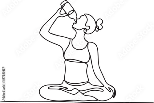 Woman drinking from bottle while meditating on floor in serene environment