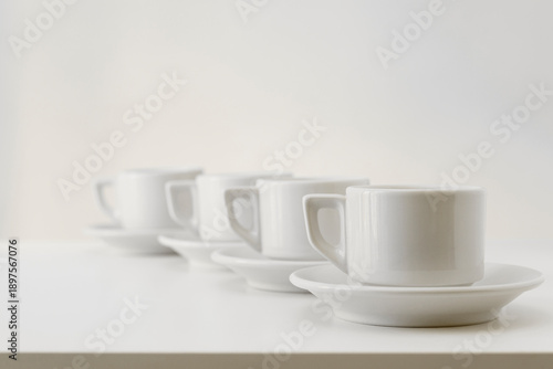 Four white cups on table