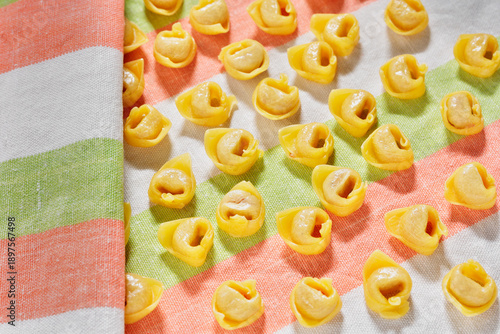 Uncooked tortellini pasta on colored cloth