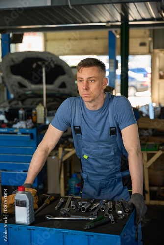Mechanic leans on a workbench in the workshop