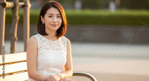 夕暮れの柔らかな光に包まれた白いレースドレスの30代日本人女性