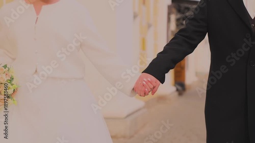 The newlyweds tenderly hold hands, they are in love with each other
