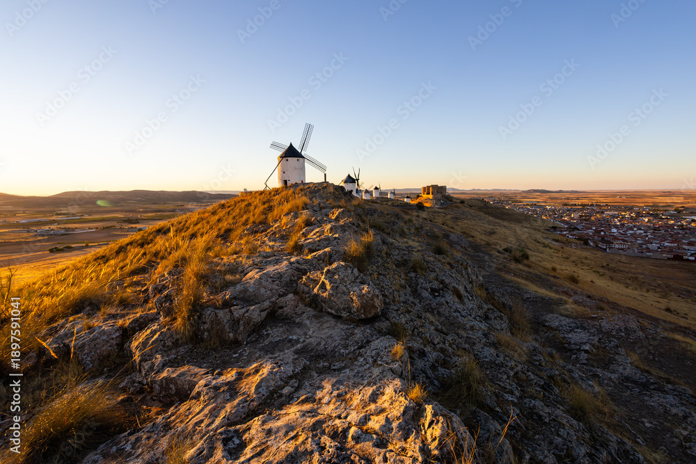 Obraz premium Consuegra windmills and castle at sunset