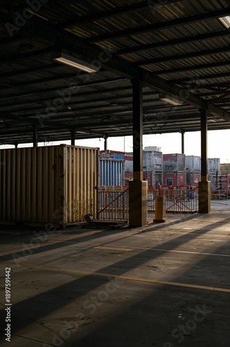 Containers Sit Under a Large Warehouse Roof in a Cargo Area During the Late A...