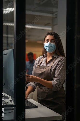 Worker Completes Task at Computer in Office During Evening Hours While Wearin...