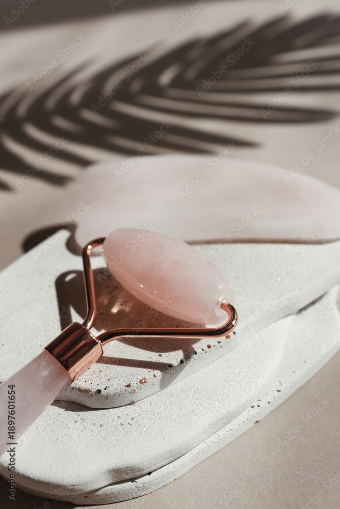 Fototapeta premium Rose quartz facial roller and gua sha stone for skincare and beauty treatments