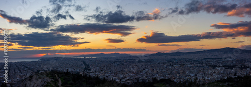 Panorama of Athens (Greece) at sunset. Mountains, sea, and picturesque clouds are visible on the horizon. 