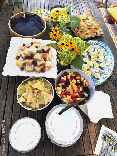 A brunch laid out on a picnic table. 