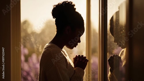 Young Black Woman Praying by Window at Sunrise, Serene and Hopeful Mood