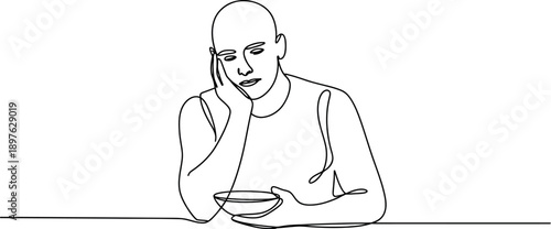 A man sitting at a table looking sad while holding a bowl of food