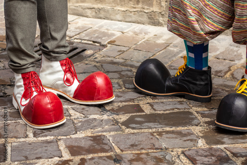 Buffe scapre da clown colorate che si incontrano in una strada di un borco antico