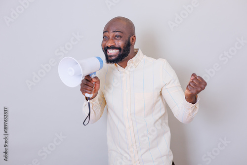 Canvas Print African american man cheering, holding megaphone, announcing good news, communic