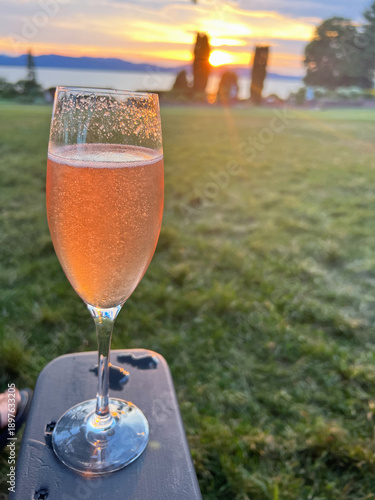 Glass of Champagne with a Lake Sunset from Field