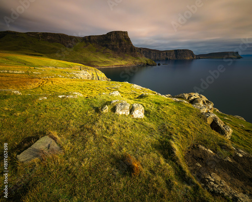Wallpaper Mural Vertical view of rugged coastal cliffs and grassy foreground at Waterstein Head on the Isle of Skye, Scotland, overlooking a calm sea under soft dramatic clouds, ideal for travel and nature concepts. Torontodigital.ca