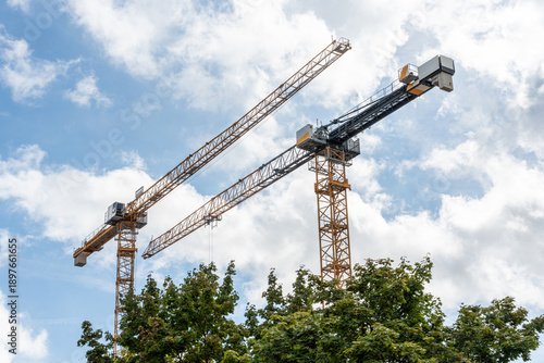 Tower cranes building urban development against sky