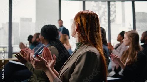 Corporate meeting with audience applauding and greeting guest speaker. Women and men present pitch during business forum, multiethnic attendees and white collar workers listen and interact. Camera A.